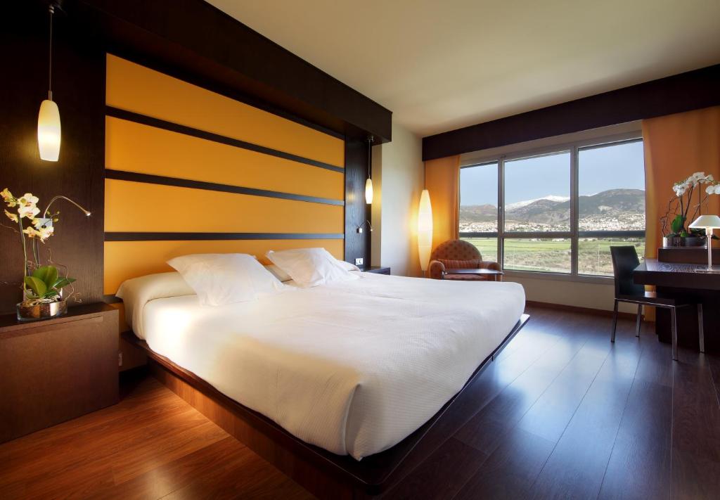 格拉纳达Hotel Abades Nevada Palace的卧室配有一张白色大床和一张书桌