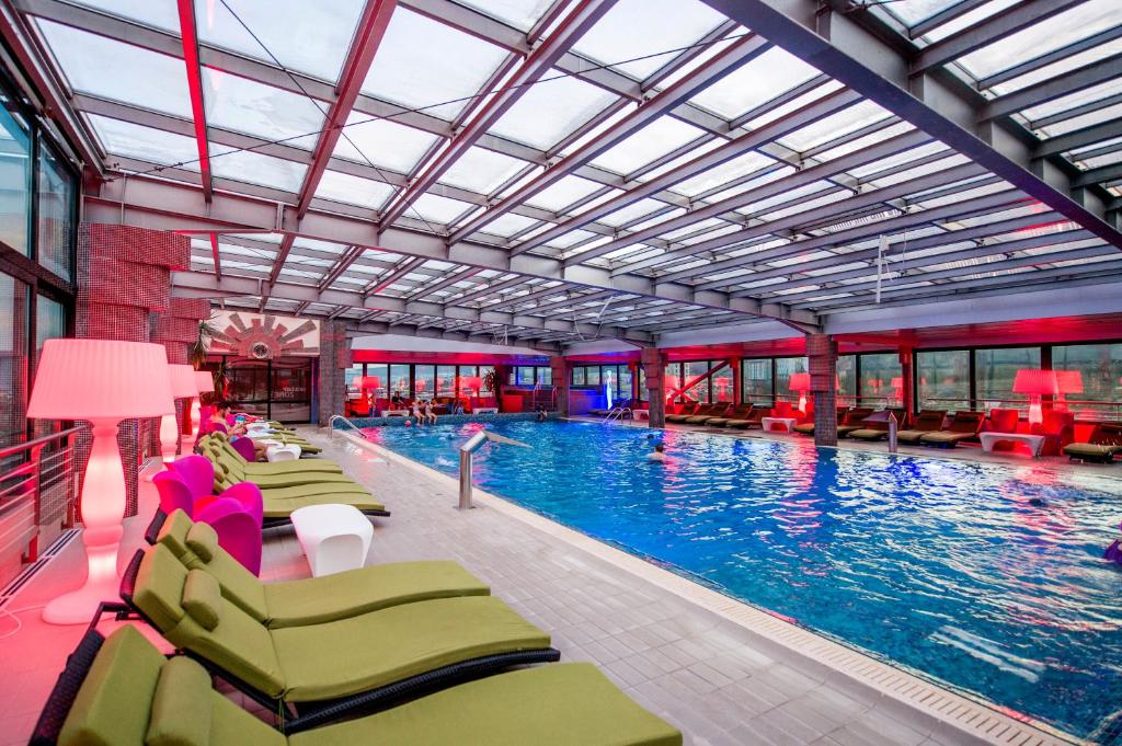 特尔古穆列什商务酒店会议中心&Spa的一个带椅子的大型游泳池,水中有人