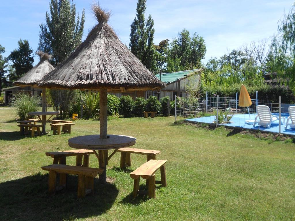 圣拉斐尔Amanecer en Cuyo的野餐桌和带稻草伞的长椅