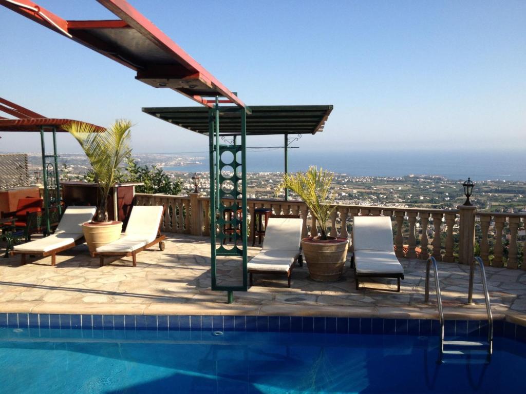 佩亚Villa Aphrodite的一个带椅子的游泳池,享有城市美景
