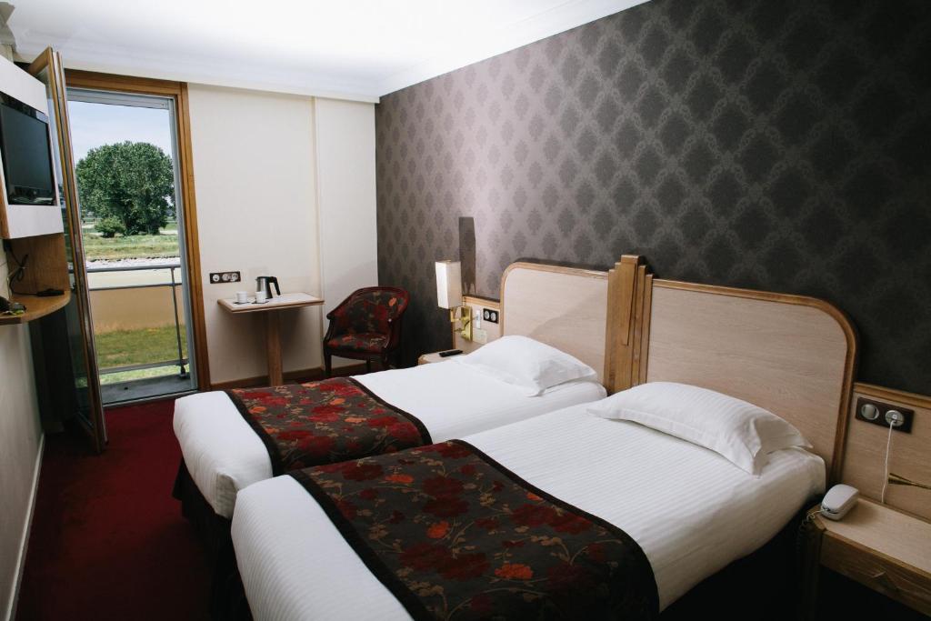 圣米歇尔山雷莱杜罗伊酒店的酒店客房设有两张床和窗户。