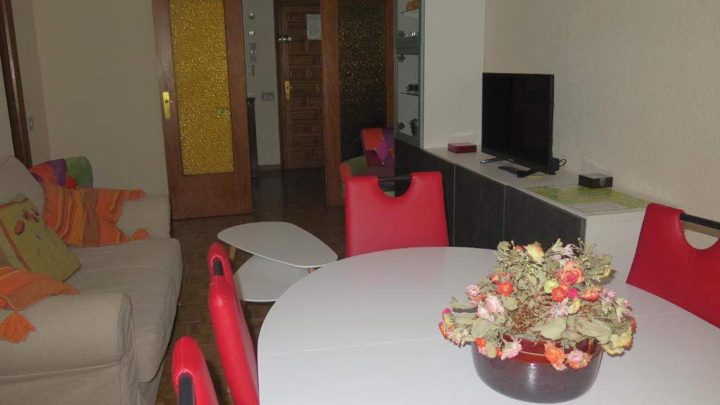 哈卡Jaca Centrum的客厅配有白色桌子和红色椅子