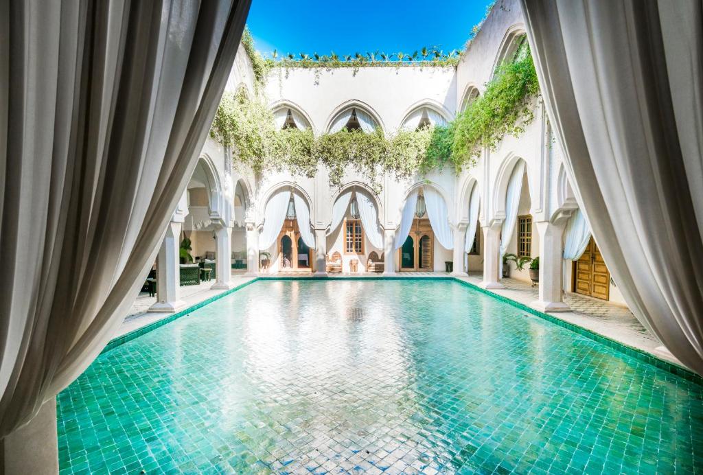 马拉喀什Almaha Marrakech Restaurant & SPA的一座带瓷砖地板的建筑中的室内游泳池