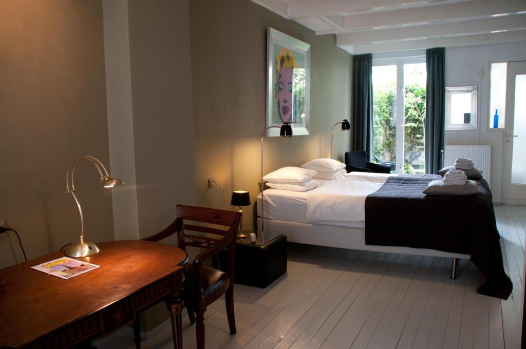 阿姆斯特丹西紫罗兰家庭旅馆的一间卧室配有一张床、一张桌子和一张书桌
