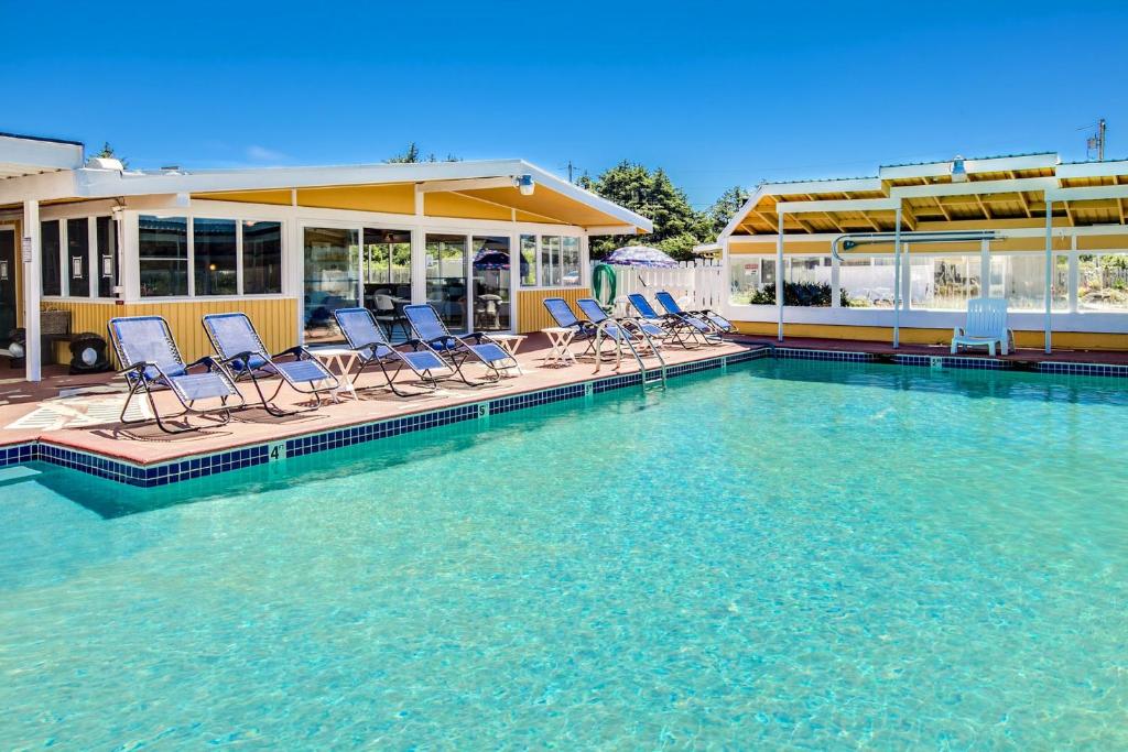 科帕利斯比奇Beachwood Condos & Resort的游泳池,游泳池配有椅子,位于水中