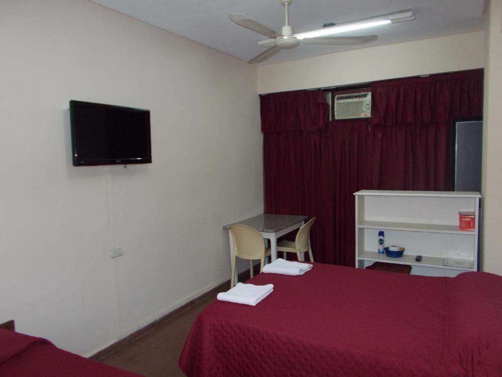 圣米格尔·德·图库玛Apart Office的一间设有床铺和墙上电视的客房