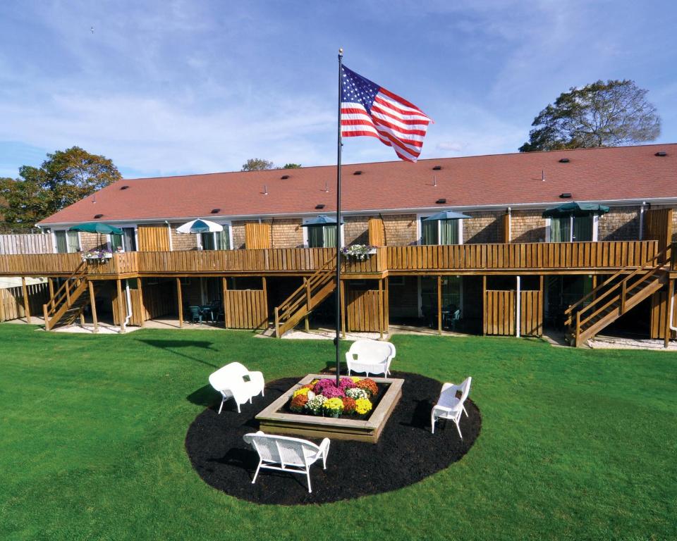 海恩尼斯Cape Winds Resort, a VRI resort的配有国旗和桌椅的小屋