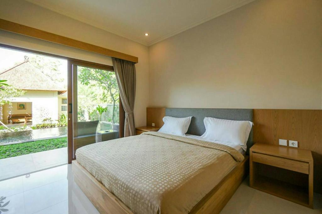 库塔阿尔纳亚民宿的一间卧室设有一张床和一个大窗户