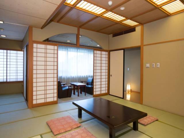 涩川市伊香保大酒店 的带桌子的客房位于带窗户的房间内
