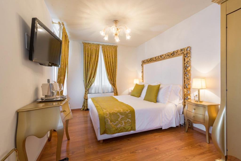 威尼斯威尼斯艾尔巴洛狄酒店的一间卧室配有一张床、一台电视和一面镜子