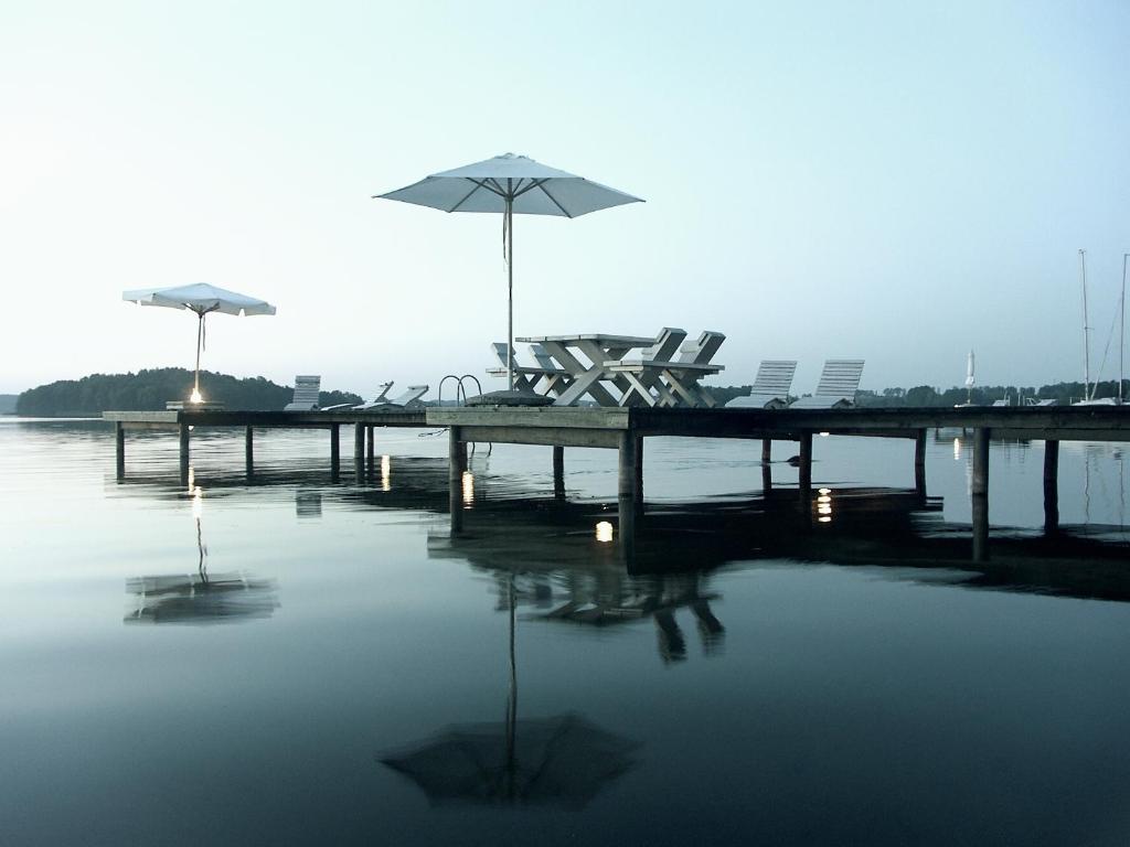 多洛托沃加勒里69旅馆的水面上带椅子和遮阳伞的码头