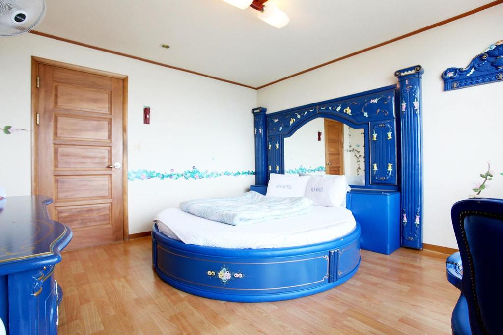 江陵市太阳汽车旅馆的一张蓝色的床,位于带桌子的房间