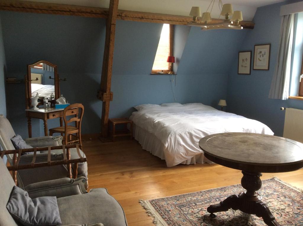 伊特尔Haras de Baudemont的卧室配有一张床和一张桌子及椅子