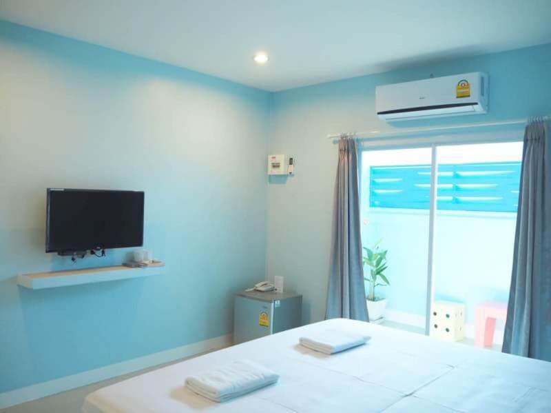 佛丕SB Inn的一间蓝色的卧室,配有一张床和一台墙上的电视