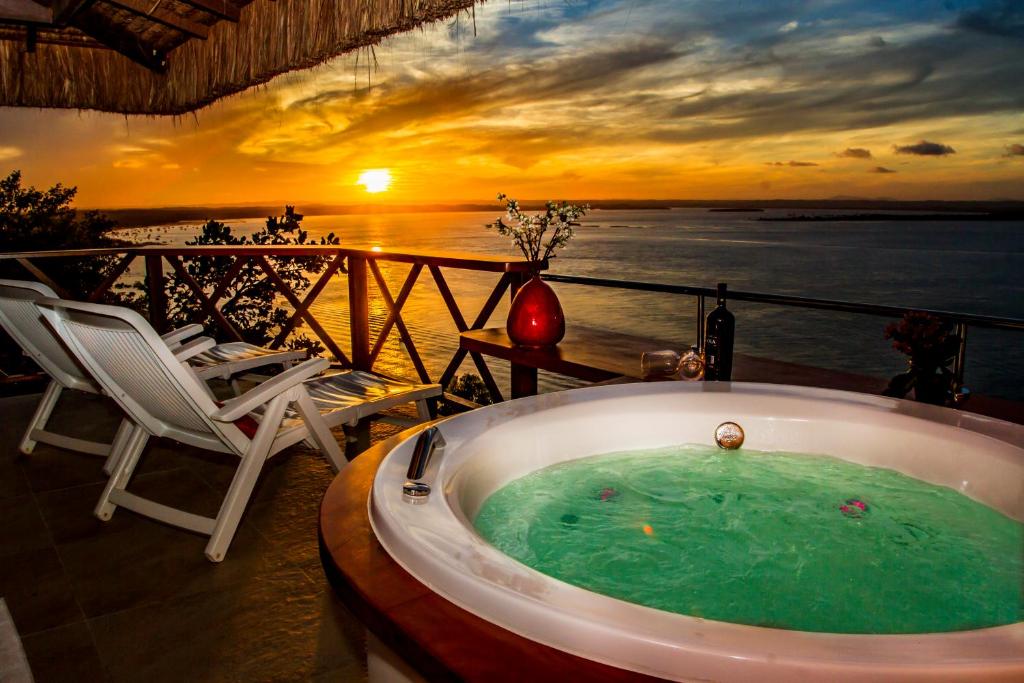 莫罗圣保罗Mar e Morro Flats的阳台上的按摩浴缸,享有日落美景
