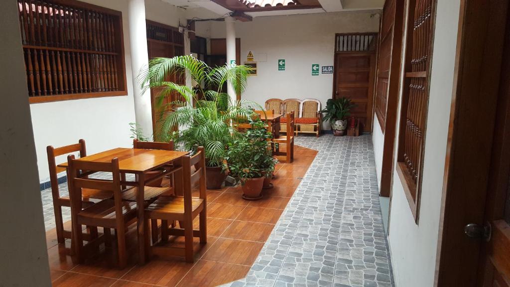 伊基托斯Amazon Green Hotel的用餐室配有桌椅和盆栽植物