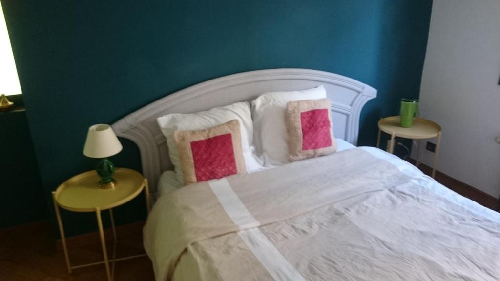 QuinsacLe Gîte的一间卧室配有带粉色和白色枕头的床