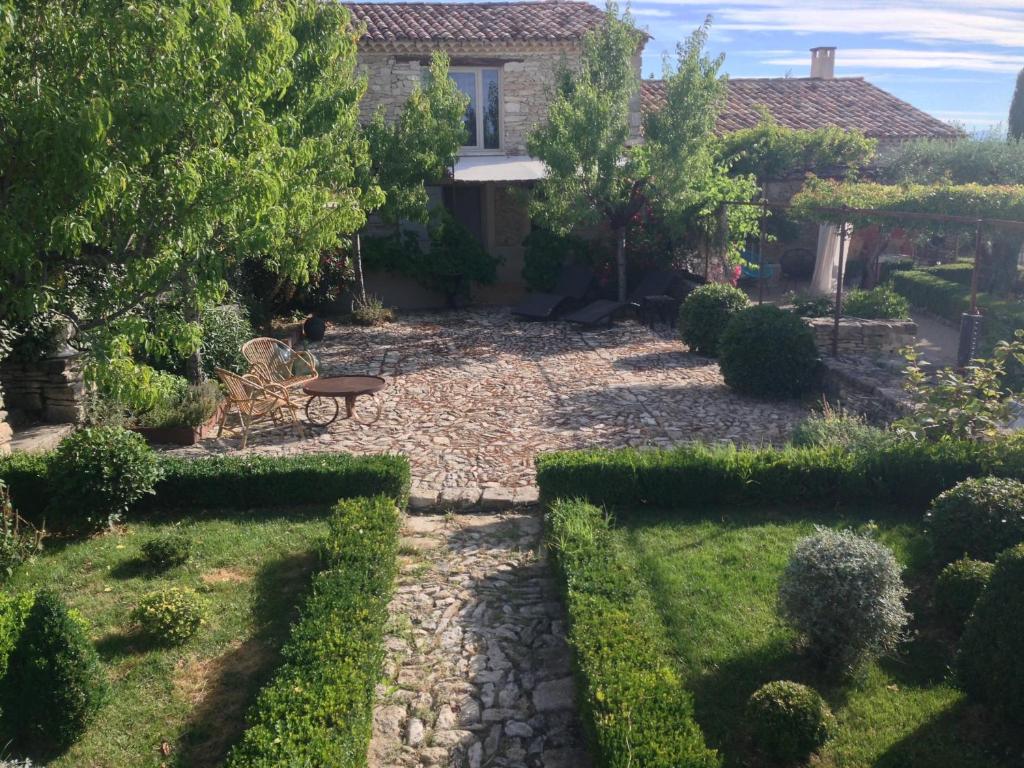 福卡尔基耶PROVENCEguesthouse L'Agace的房屋前设有带桌子和长凳的花园