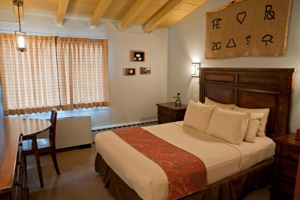 比林斯多德牧野别墅酒店的一间卧室配有一张床、一张桌子和一个窗户。