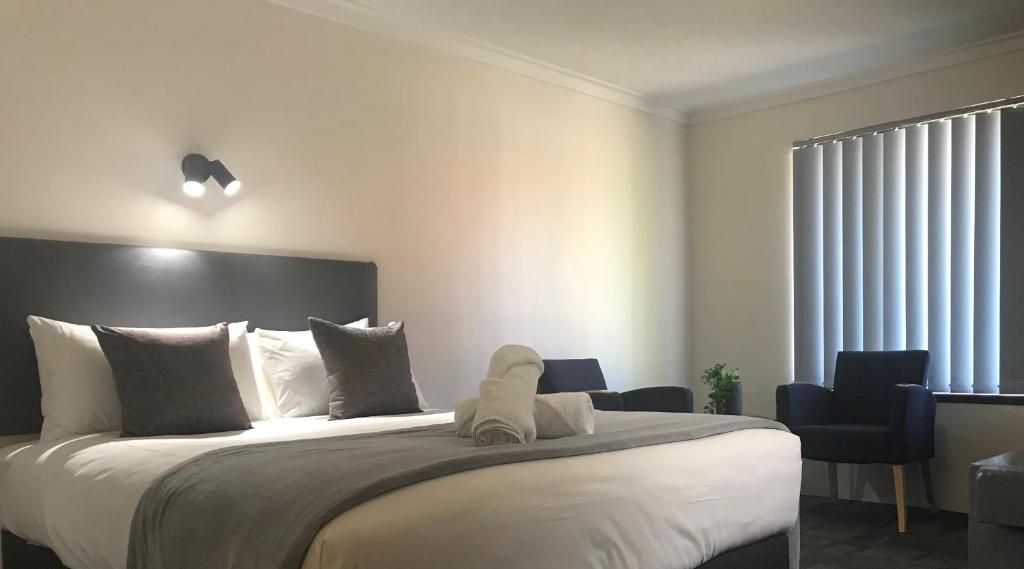 罗金汉姆Hotel Clipper的一间卧室配有一张大床,上面有毛巾