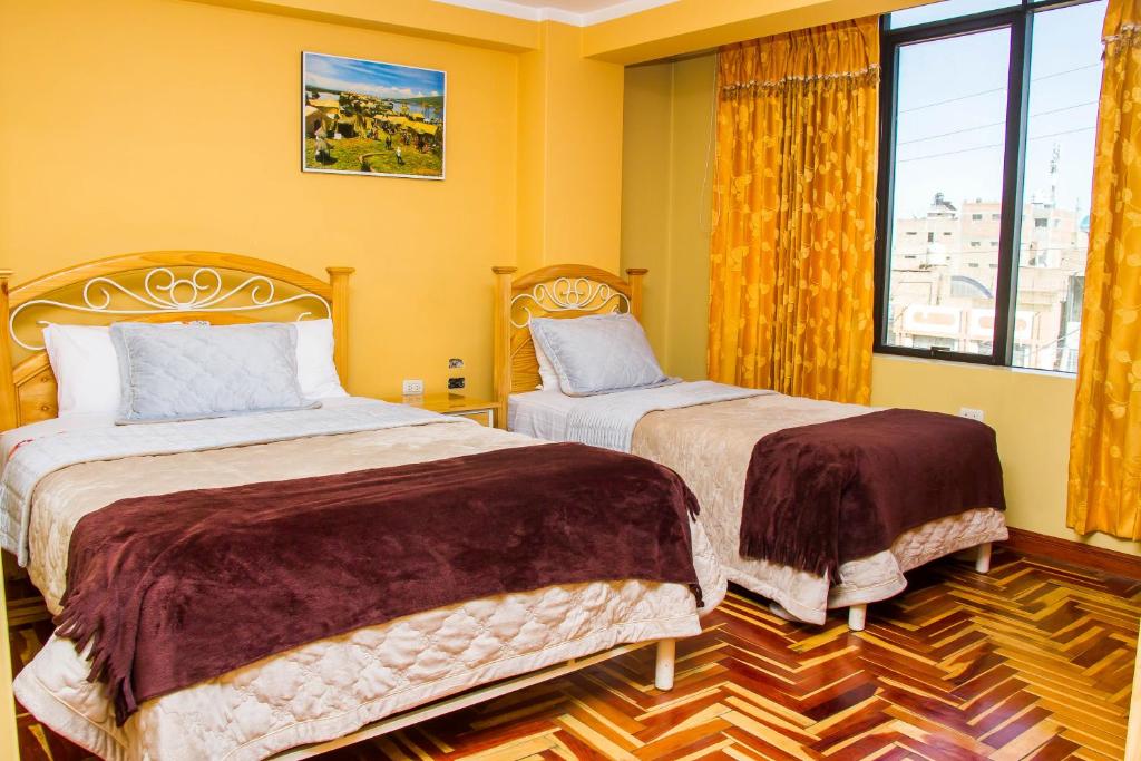 胡利亚卡Rayos Del Sol的卧室设有两张床,拥有黄色的墙壁和窗户。