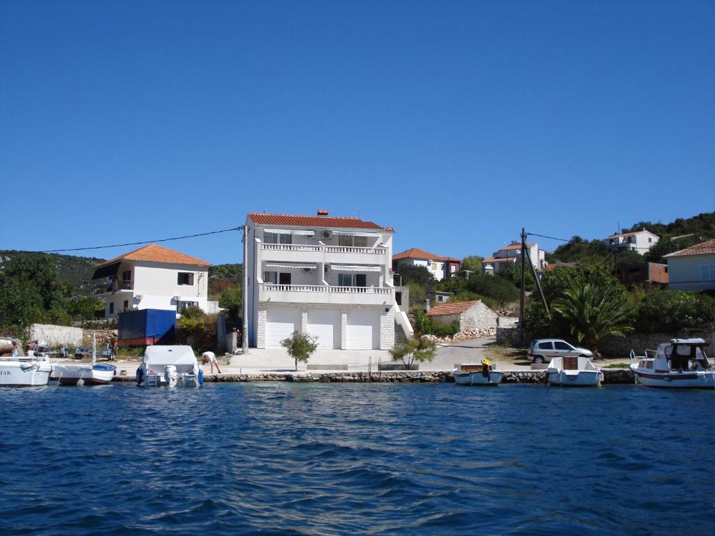 维尼斯切Apartments Mirko的码头上的房子,水中有船