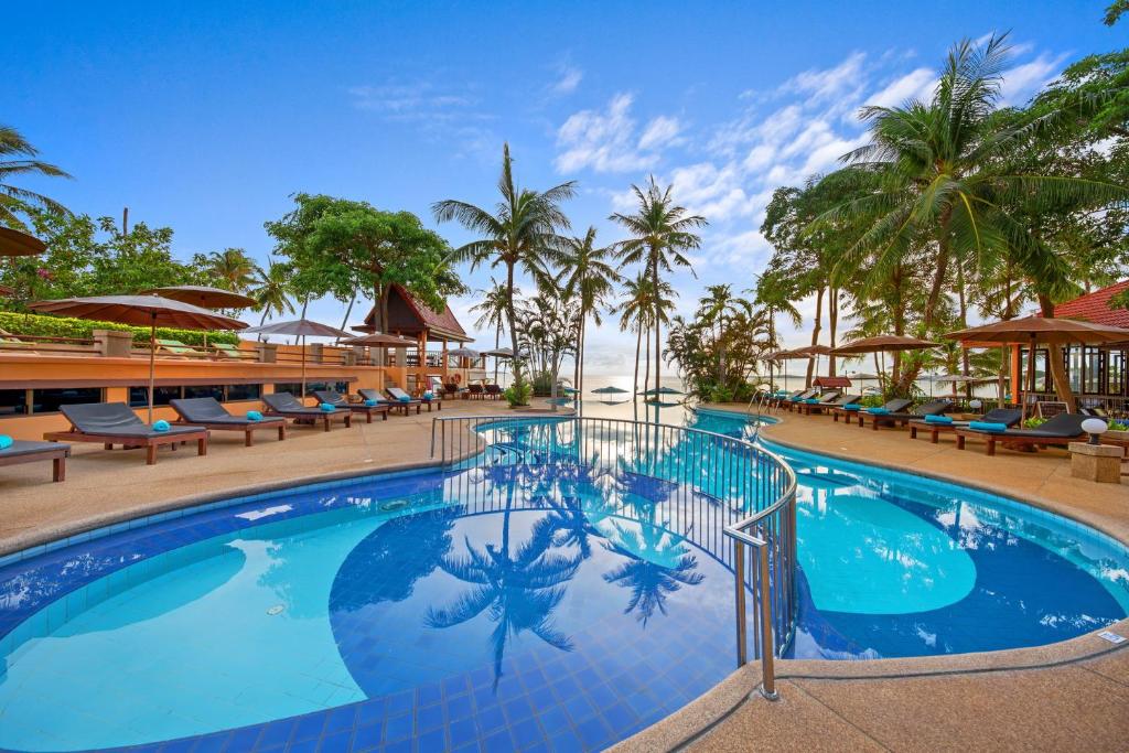 湄南海滩Pinnacle Samui Resort SHA Plus的一个带椅子和棕榈树的度假村游泳池