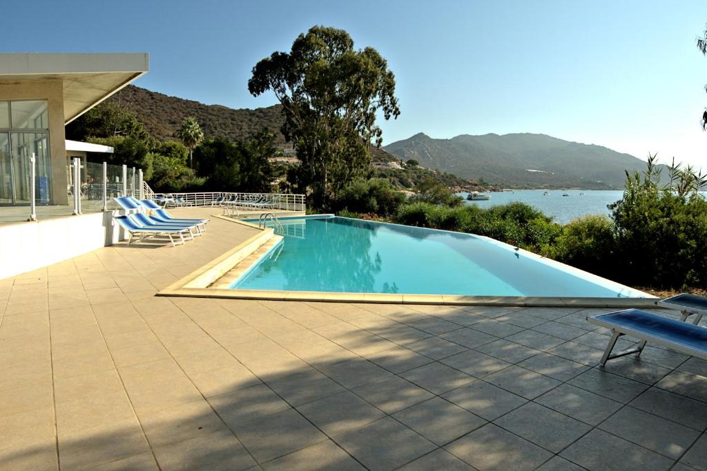 阿雅克修Hotel la Parata的一个带椅子的游泳池,享有水景