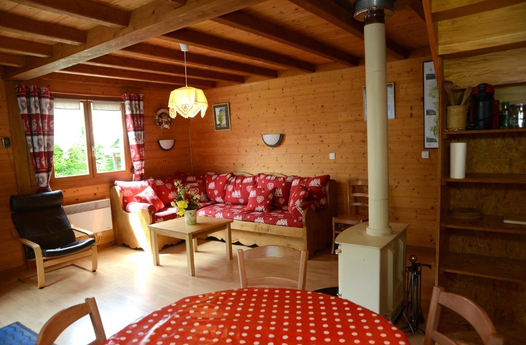 Marignychalet des planchettes的客厅配有红色的沙发和桌子