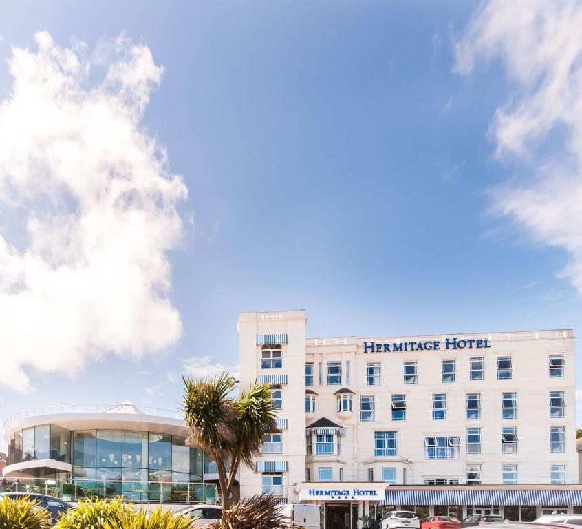 伯恩茅斯The Hermitage Hotel - OCEANA COLLECTION的一座酒店大楼,前面有棕榈树