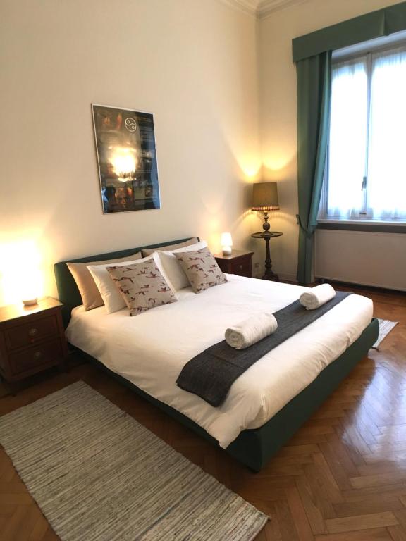 都灵Appartamenti Politecnico的卧室配有一张带白色床单和枕头的大床。