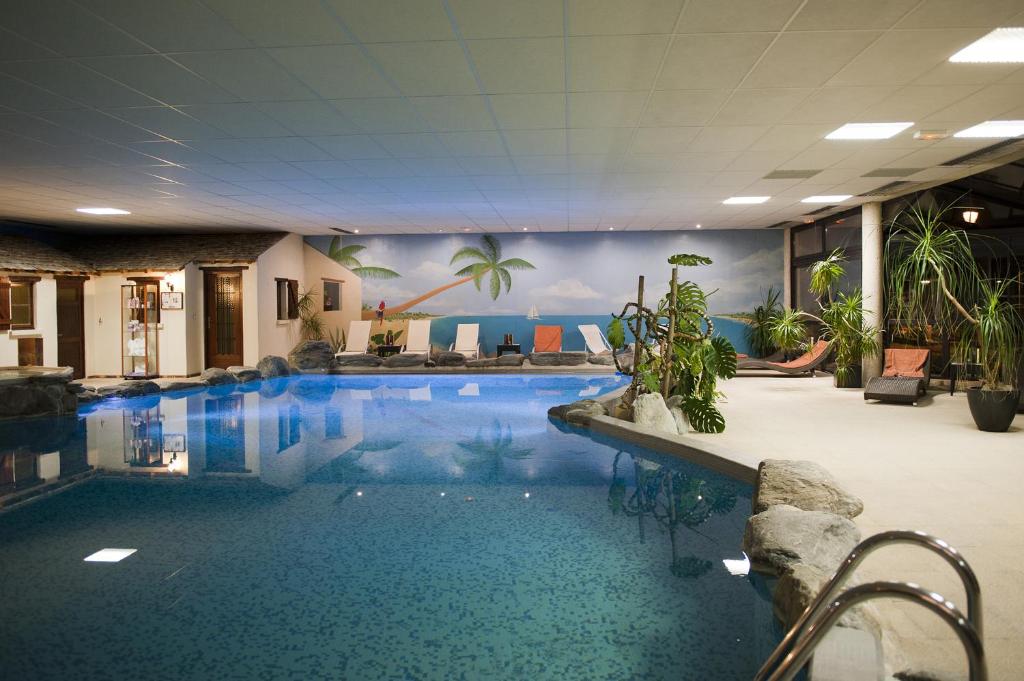 Chassey-le-Camp罗曼营地酒店的大楼内一个蓝色的大型游泳池