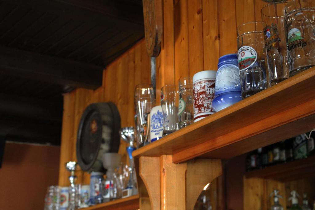 PilisvörösvárGilde étterem és panzió的架子上装有玻璃杯和其他物品