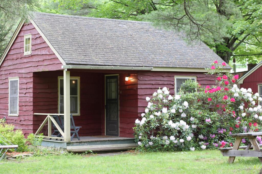 腓尼基Phoenicia Lodge的红色的小房子,有门廊和鲜花