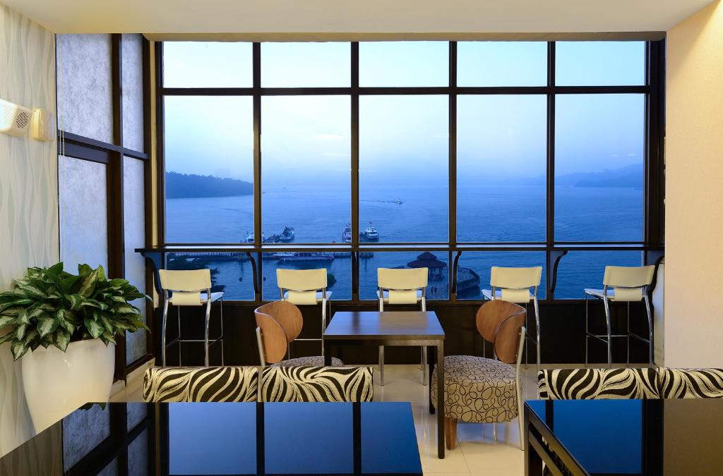 鱼池乡湖悦景观旅店的客房设有桌椅和大窗户。
