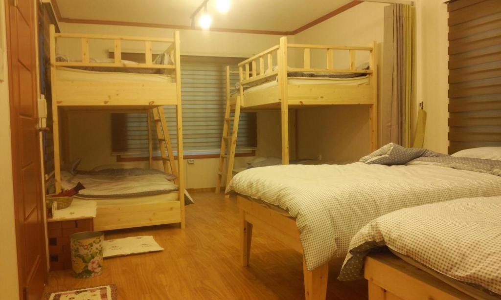 巨济巨济敦通旅馆的一间卧室配有两张双层床和一张书桌