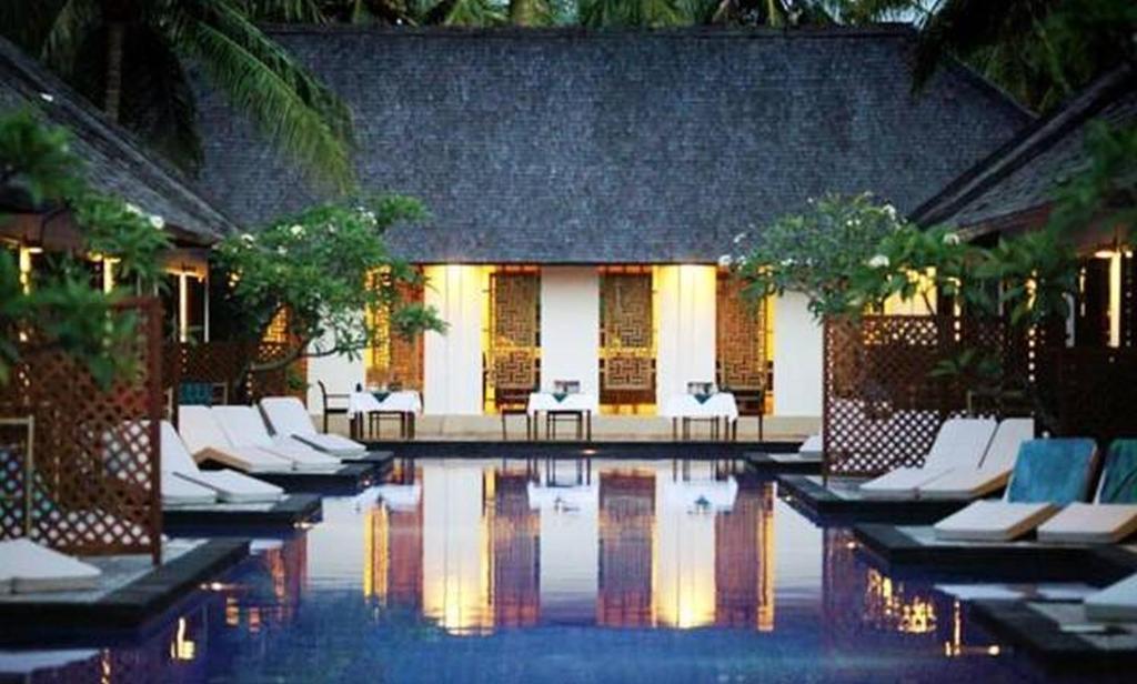 吉利特拉旺安卢斯阿尔玛套房度假村&Spa的度假村内带白色躺椅的游泳池