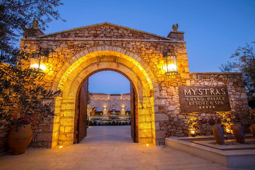 米斯特拉斯Mystras Grand Palace Resort & Spa的一座带拱门的石头建筑的入口