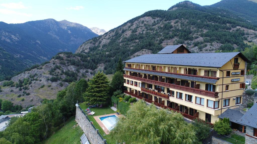 奥尔迪诺Abba Ordino Babot Hotel的一座带游泳池和山脉的建筑