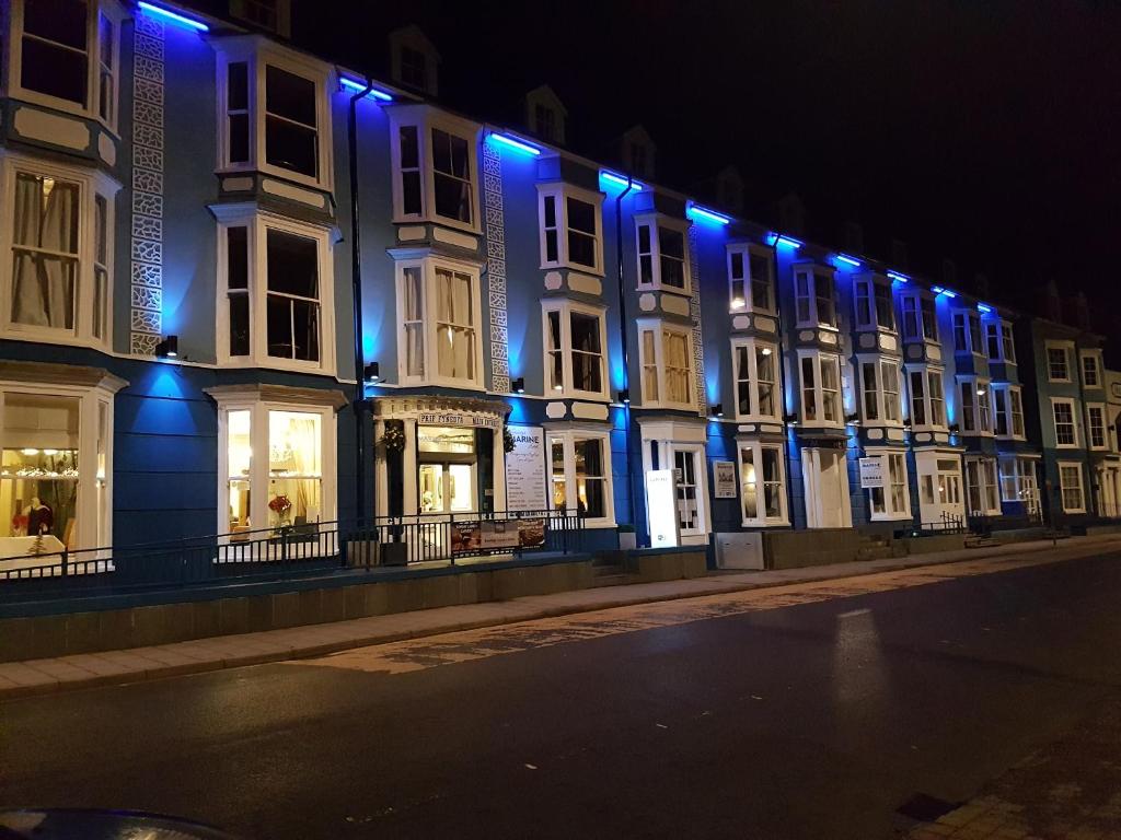 阿伯里斯特威斯Gwesty'r Marine Hotel & Spa的上面有蓝色的灯光的建筑物