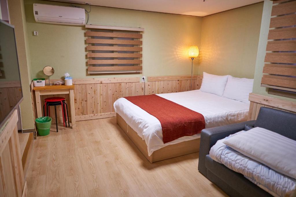 首尔首尔站R旅馆的一间卧室配有一张床和一张沙发
