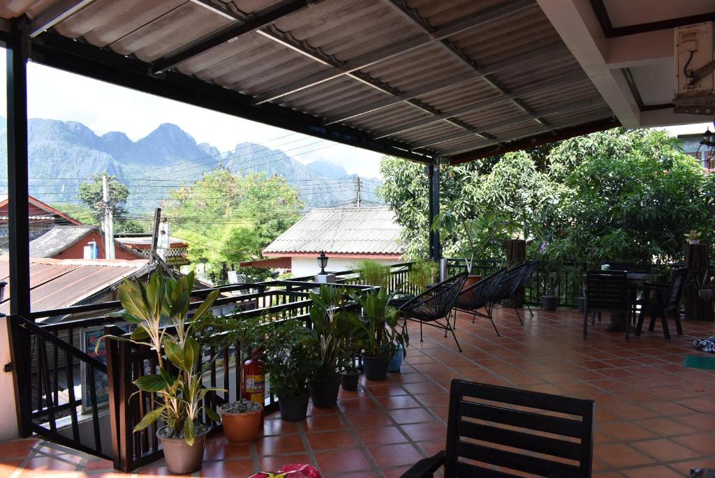 万荣美景旅馆的庭院内种有椅子、植物和山脉