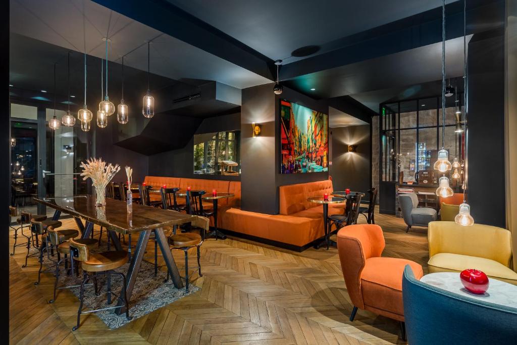 巴黎斯嘉丽酒店的用餐室配有橙色椅子和桌子