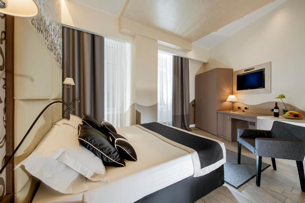 罗马戴美塔酒店的配有一张床和一张书桌的酒店客房
