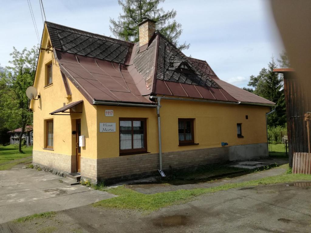 SmržovkaHaus Marta的一座黄色的房子,有金属屋顶