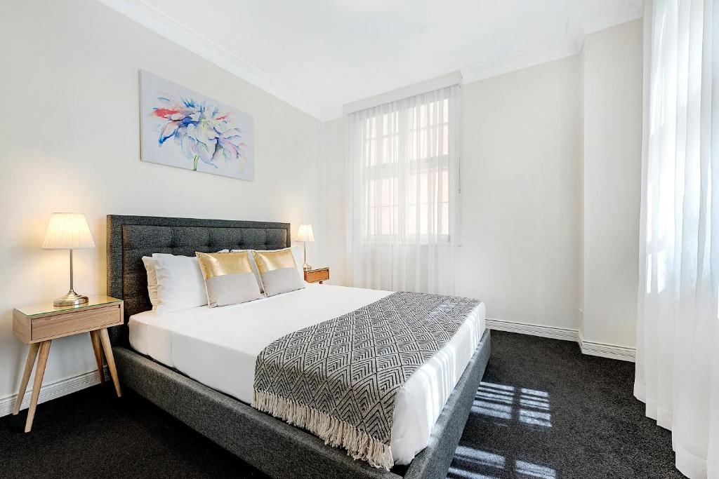 布里斯班ULTIQA罗斯伯里公寓的白色的卧室设有床和窗户