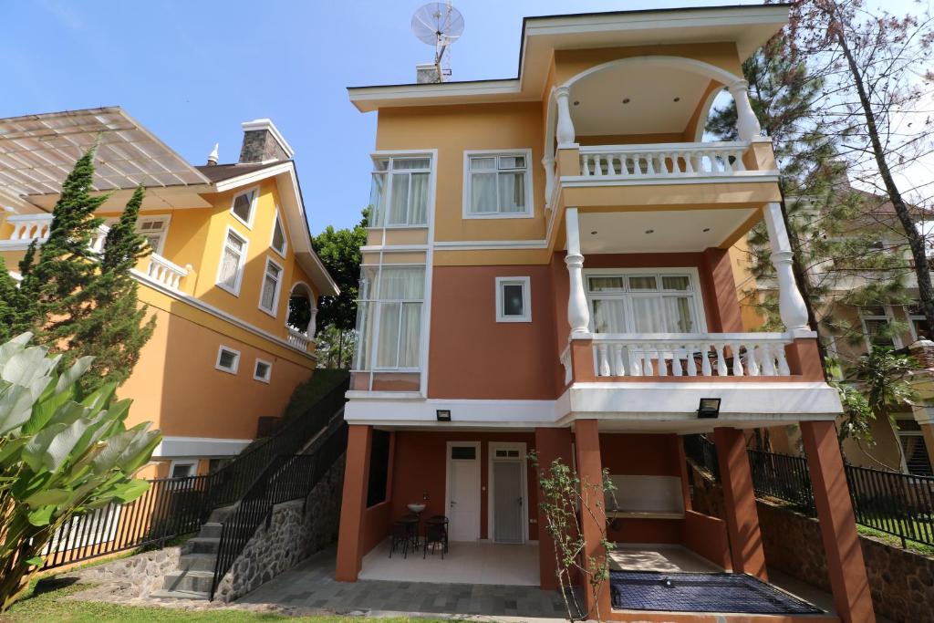普卡Diyar Villas Puncak NB3/3的带阳台的黄色房屋