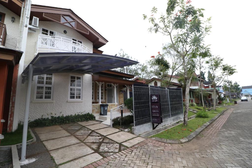 普卡Diyar Villas Puncak Q4/11的街道边带雨伞的房子