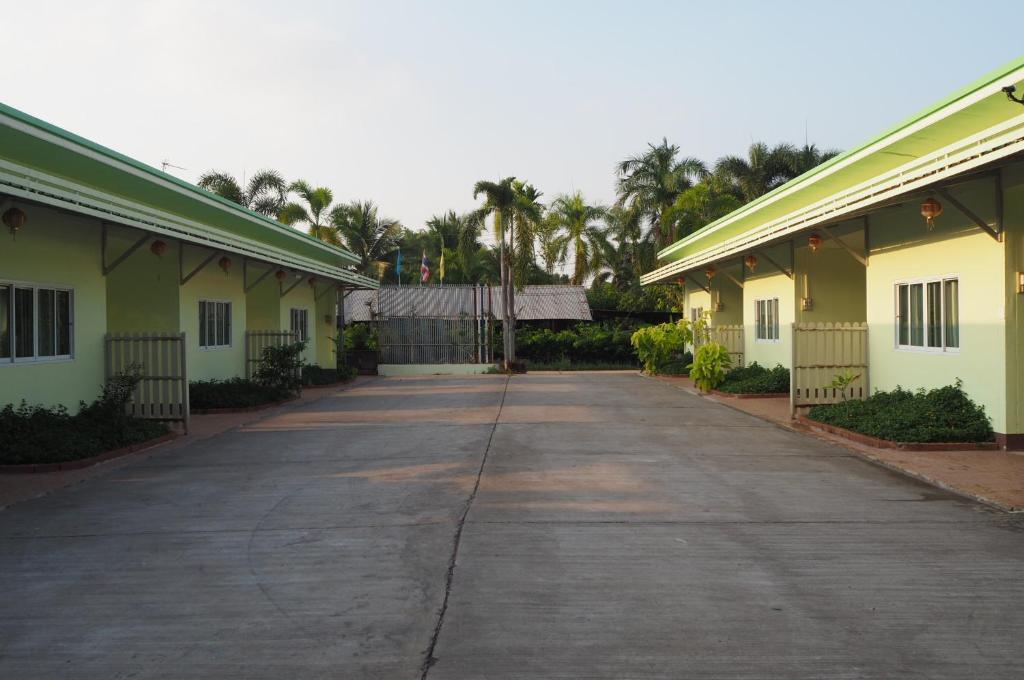 乌隆他尼555 Resort的两座棕榈树建筑之间的空洞道路