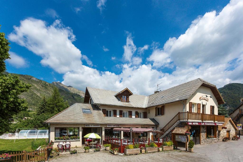 昂塞勒Hotel restaurant Le Chamois的一座大房子,背景是群山